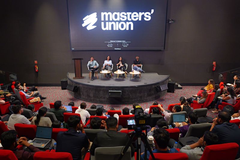 Pushpak Teja speaking on a panel in a full Masters’ Union auditorium